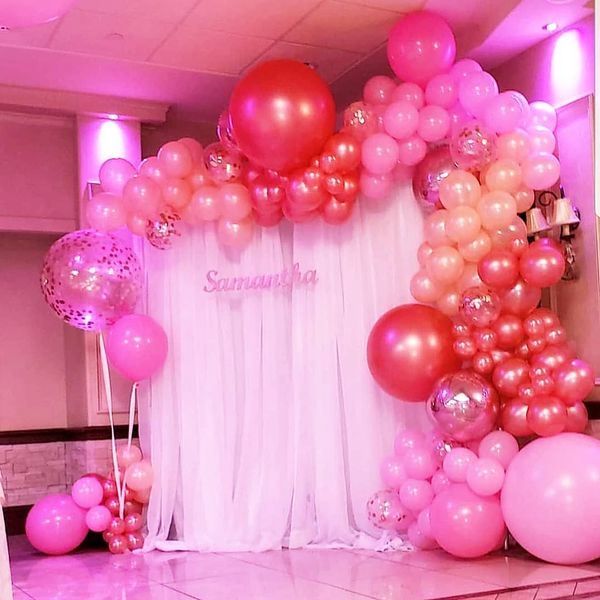 Pink and rose gold balloon garland on a sheer white backdrop for this sweet 16 with laser cut wooden
