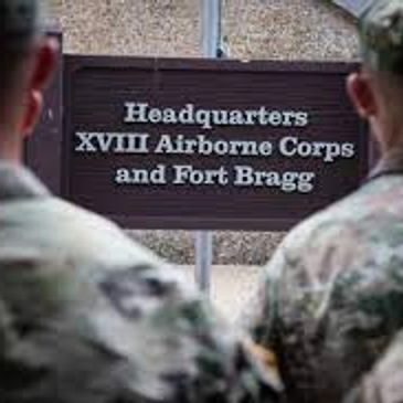 Soldiers standing in front of Ft Bragg sign.