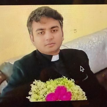 A man in a clerical collar holding a bouquet of flowers.