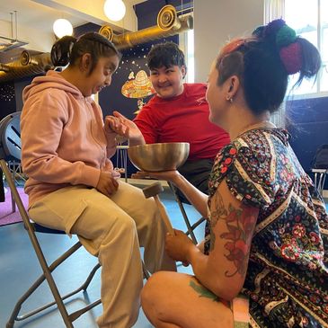 Three people engaging in a joyful group activity indoors.
