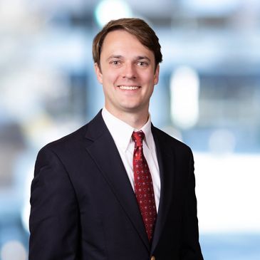 A man in a suit smiling at the camera.