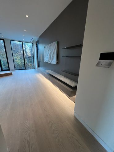 Modern living room with large windows and sleek built-in shelves.