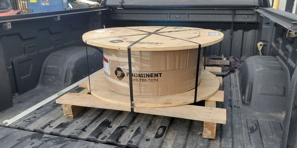 Large wooden spool in back of a truck.