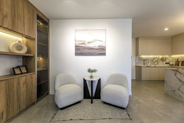 Modern minimalist sitting area with two gray chairs and a small table.