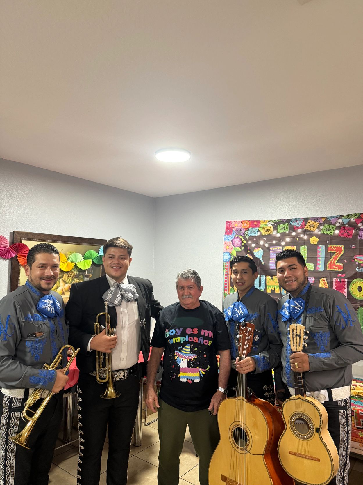 Birthday celebrant with mariachi band in colorful festive setting.