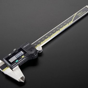 Digital caliper measuring tool on a dark surface.