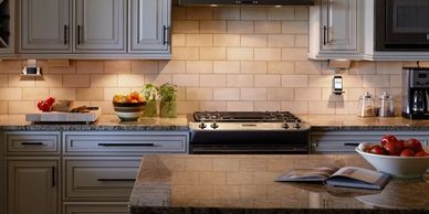 Modern kitchen with granite countertops and stainless steel stove.