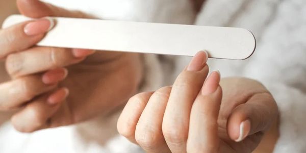 Person filing fingernails with a nail file.