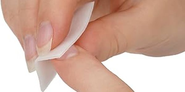 Hand wiping a finger with a small white cloth.