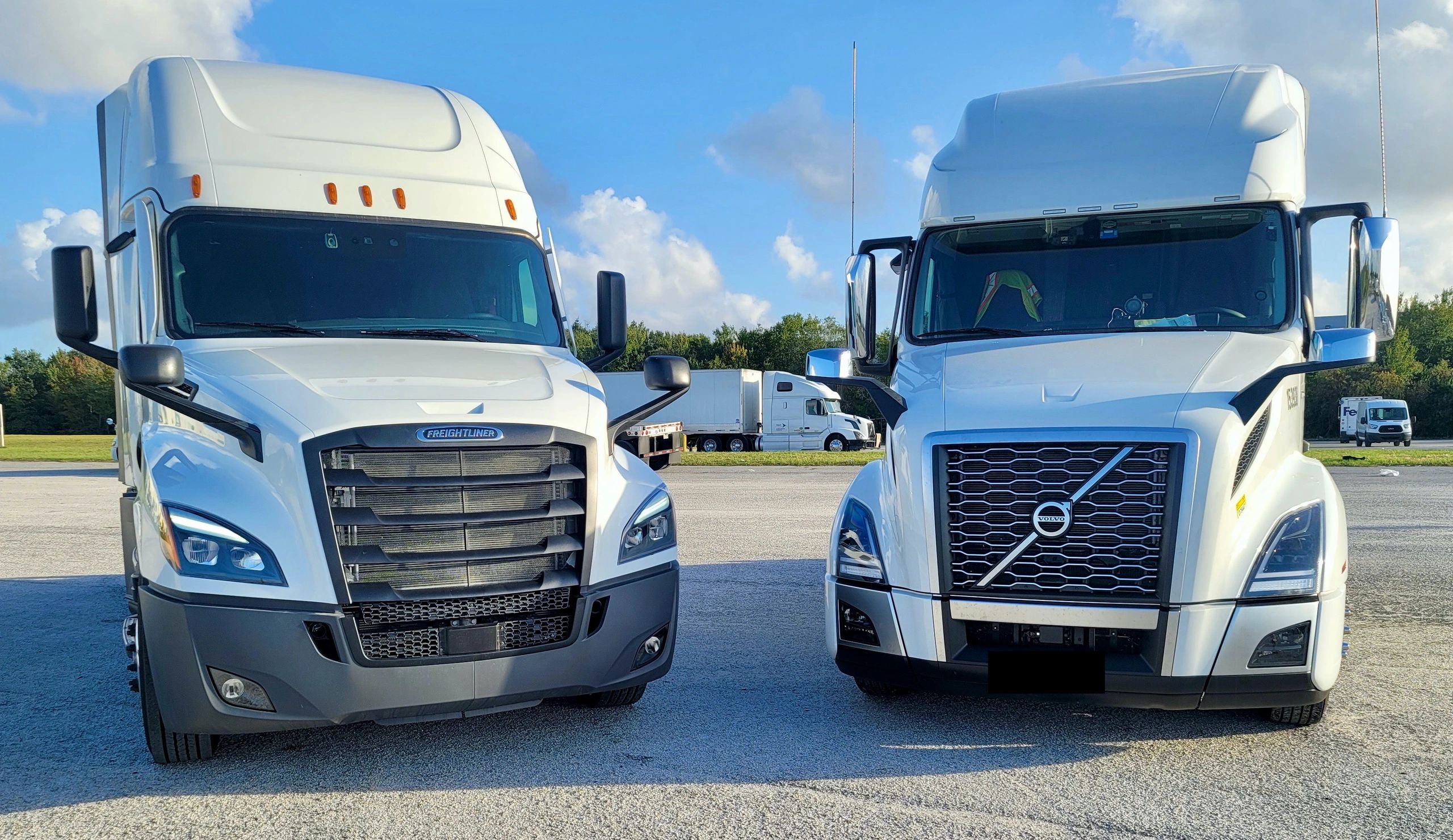 Two white delivery trucks