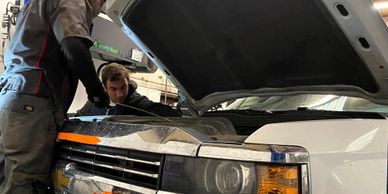 Alex and Greg performing services to a Chevrolet 2500.