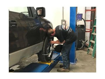 Alex performing a wheel alignment on a 2004 Ford F-150 XLT.