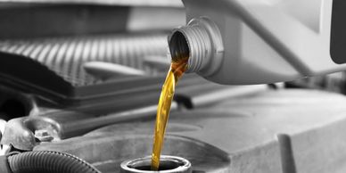 Photo of oil being poured into an engine.