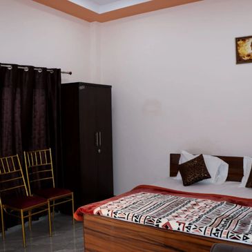 Cozy bedroom with wooden furniture, plush bedding, and a Buddha painting on the wall.