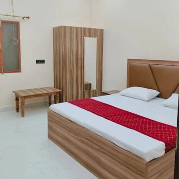 Simple bedroom with wooden furniture and modern ceiling lights.