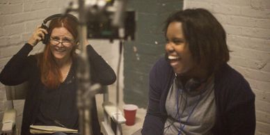 Two women laughing and enjoying a moment together indoors.