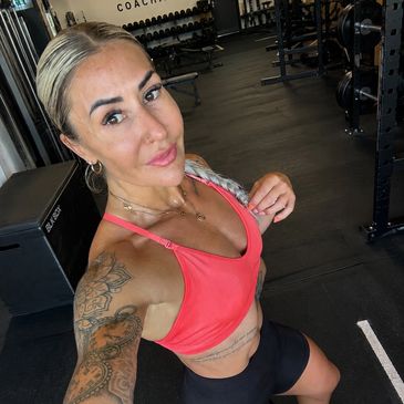 Woman taking selfie at the gym in workout clothes.