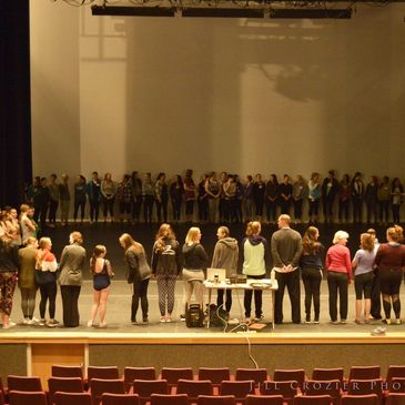 Large group gathered onstage and auditorium.