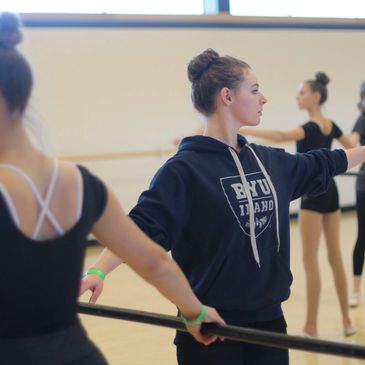 Young ballet dancers practicing at the barre.