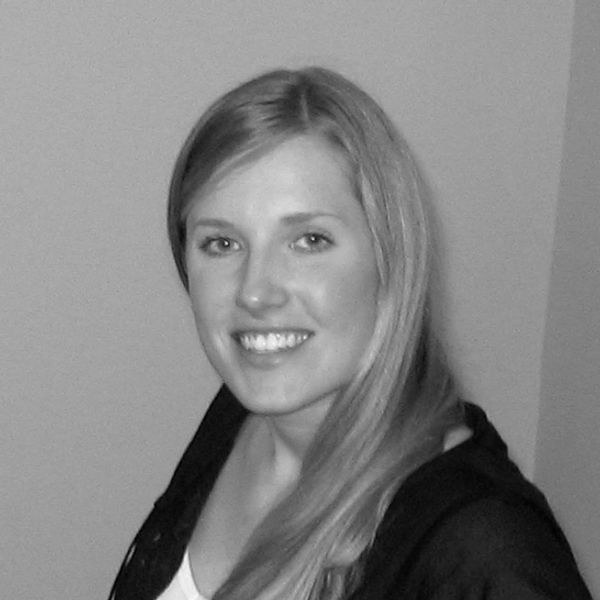 Black and white portrait of a smiling woman with long hair.