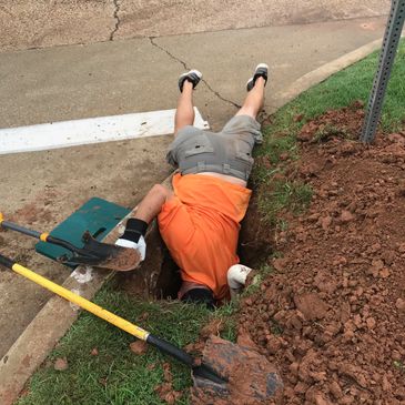 A technician repairing a commercial sprinkler line very deep