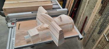 Wooden model of an airplane on a table saw in a workshop.