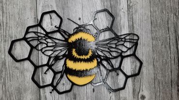 Decorative bee artwork with honeycomb design on wooden background.