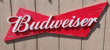 A vintage Budweiser sign on a wooden wall.