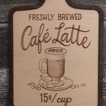 Wooden sign advertising freshly brewed café latte for 15 cents per cup.