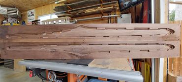 Wooden boards carved with car-shaped outlines in a workshop.