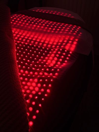 Red dotted light pattern on a dark bed.