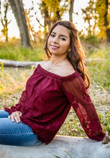 young lady sitting on a log at McKay Lake for her senior picture session