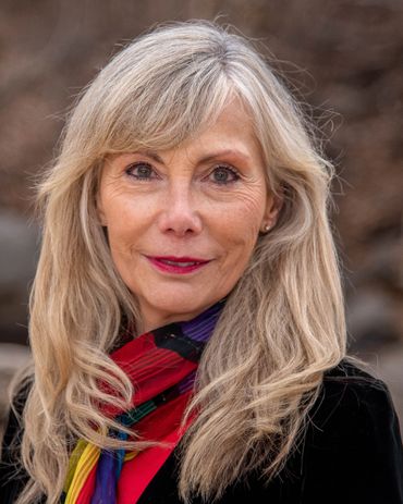 older woman with a scarf around her neck, smiling