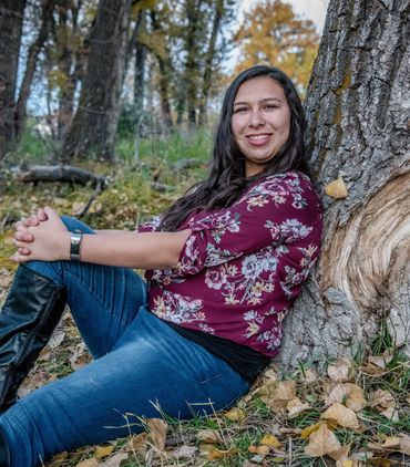 young high school girl casually leaning against a tree at McKay Lake for her senior picture