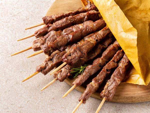 A close-up of several grilled meat skewers.