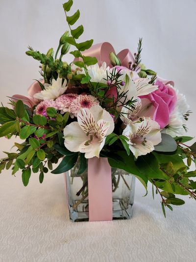 Mix colors floral arrangement is a squqre clear vase.