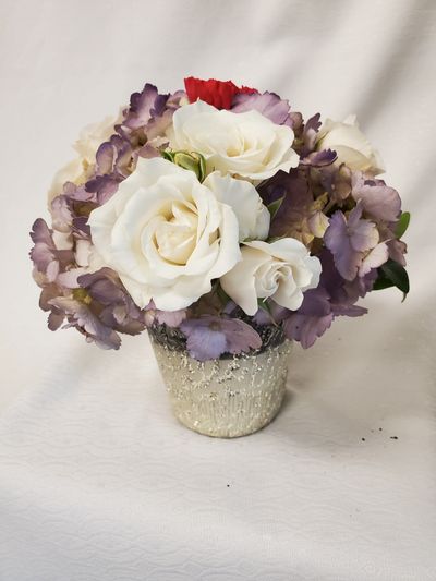 small and nice white roses and purple hydrangeas in a golden ceramic vase.Oceana Florist deliver flowers in Vancouver. We are Vancouver house of flowers, Prince Rupert Florist & King Edward Florist.