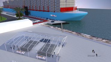 A large blue boat is docked in the water.