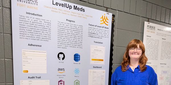 Woman standing next to a Purdue University Fort Wayne research poster.