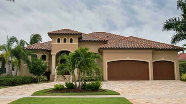Mediterranean-style house with tiled roof and three-car garage.