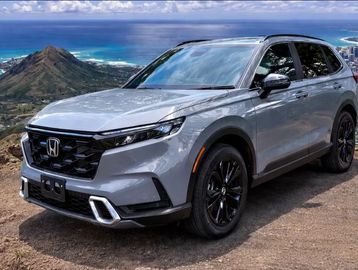 Silver Honda SUV parked on a mountain with ocean view.