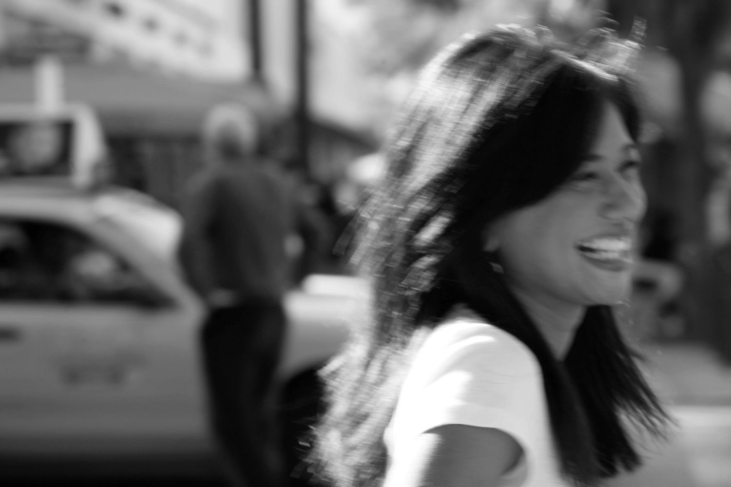 Image of Maritza smiling. There's an image of a man and taxi in the background. 
