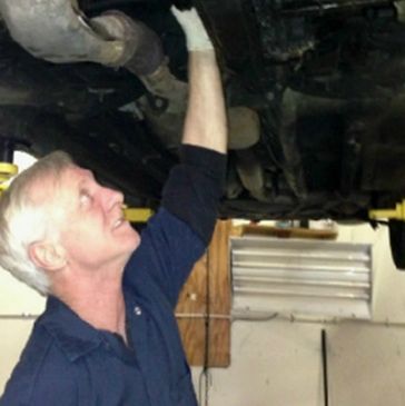 Garage owner Matt Wright repairing an exhaust muffler