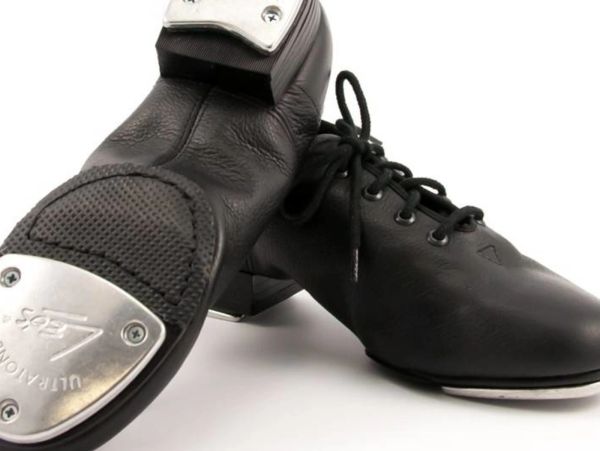 Black tap dance shoes with metal taps on sole and heel.