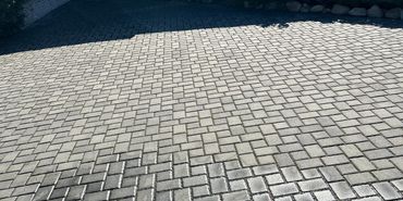 House entrance with red door and paved driveway under clear blue sky.