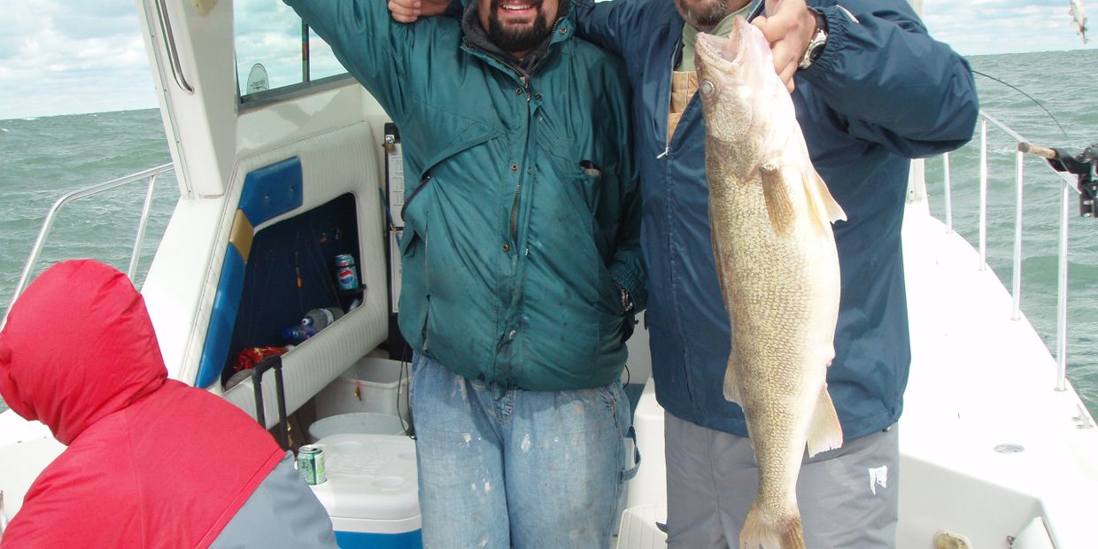 Two delighted Osprey Lake Erie Fishing Charter clients showing their huge catch.
