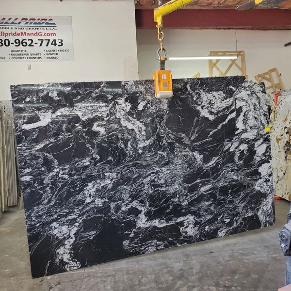 Large black and white marble slab in a warehouse.