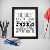 Framed inspirational advertising quote on a desk with office supplies.