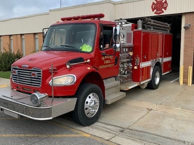 A red fire truck parked outside a fire station.