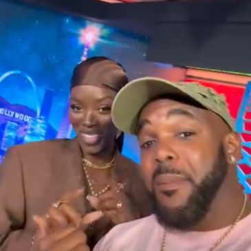 Two people posing for a selfie in a colorful studio.